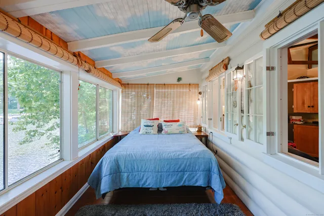 a bedroom with a bed and large windows