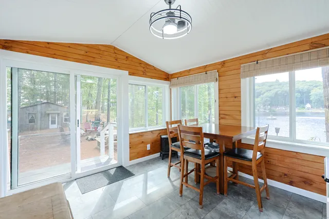 a dining room with furniture and large windows