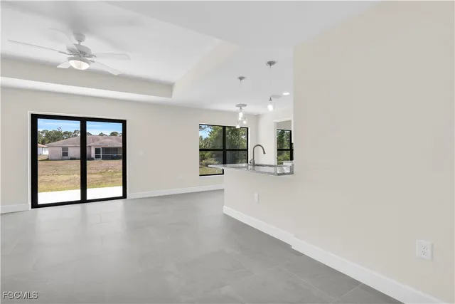 an empty room with windows and ceiling fan