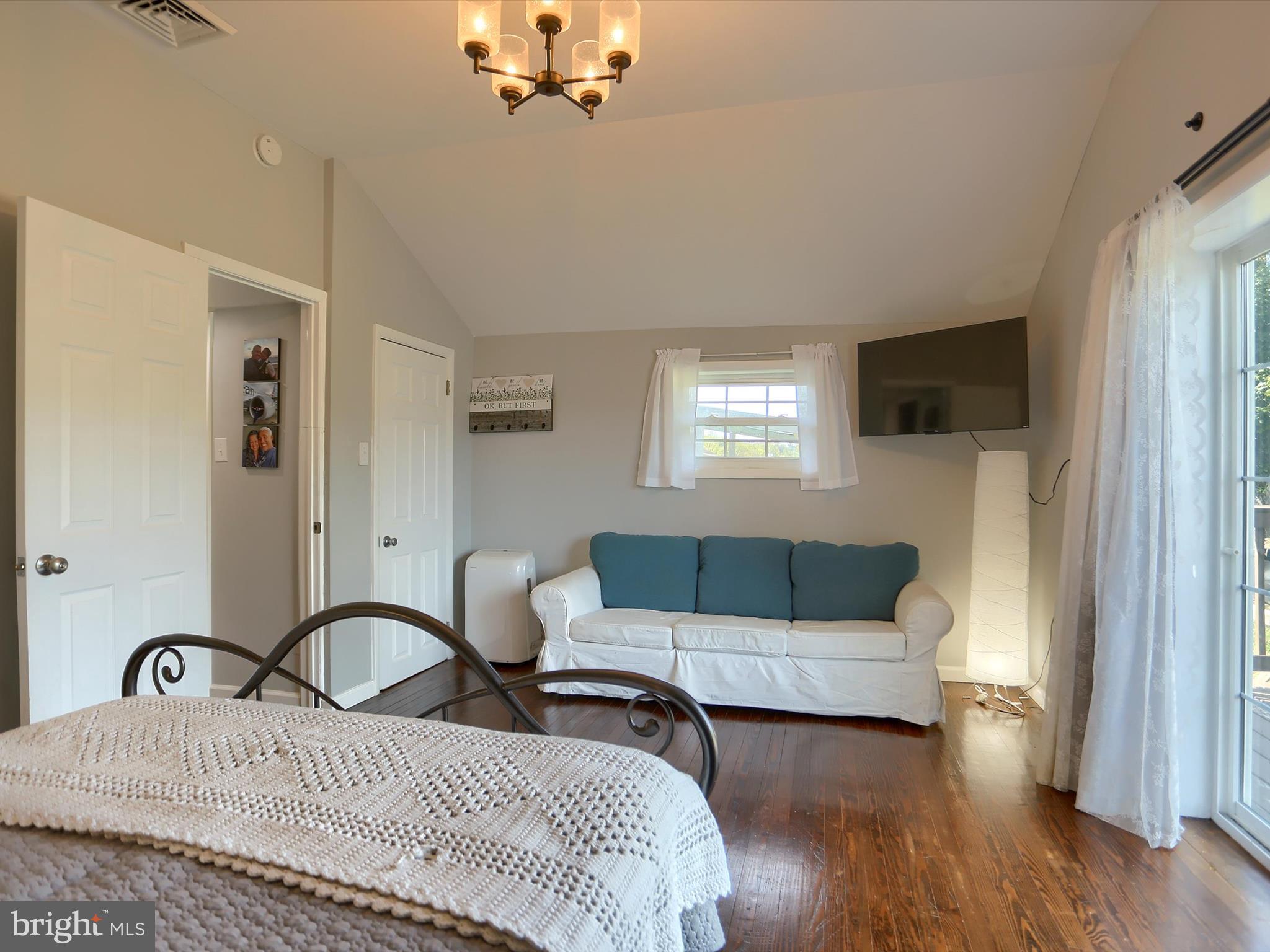 5931 York Road Spring Grove, PA 17362 - Photo 23 of 38 a bedroom with a bed a couch and a window with wooden floor