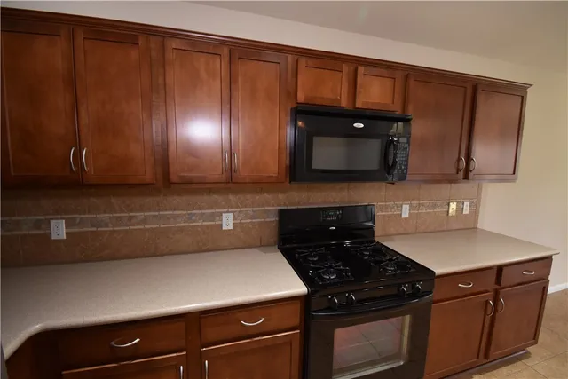 a kitchen with wooden cabinets and a stove top oven