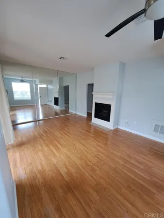 a view of empty room with wooden floor and fireplace