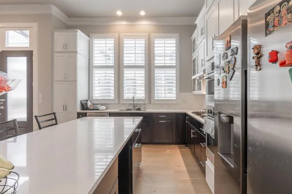 a large kitchen with kitchen island granite countertop a large window and stainless steel appliances