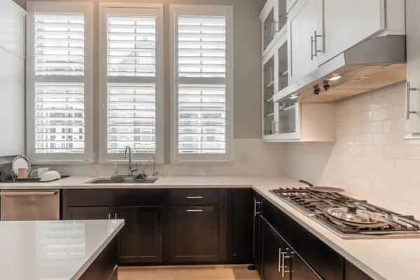 a kitchen with stainless steel appliances a sink stove and cabinets