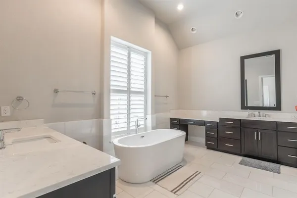 a bathroom with a tub sink and mirror