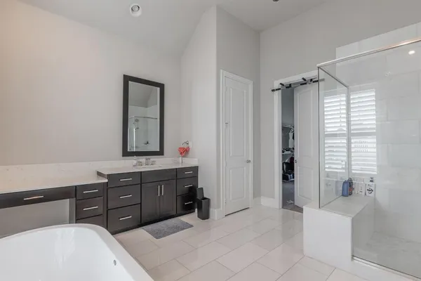 a spacious bathroom with a tub sink and mirror