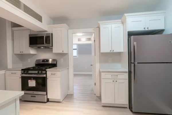 a kitchen with stainless steel appliances a refrigerator stove and microwave