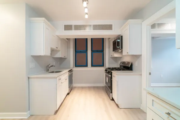 a kitchen with a sink stove and cabinets