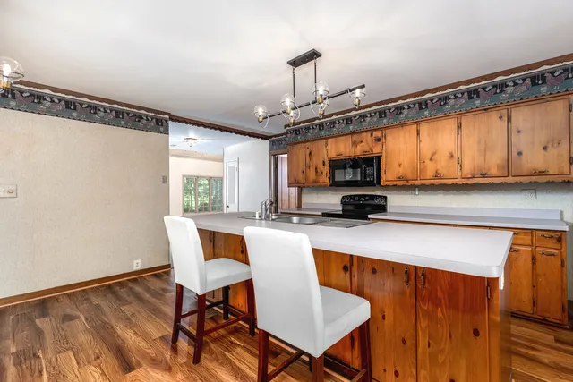 a kitchen with a table chairs and wooden floor