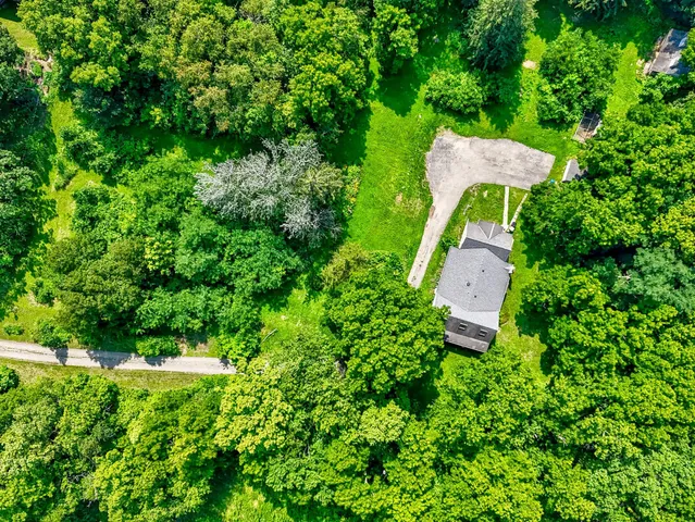 an aerial view of a house with pool table and chairs