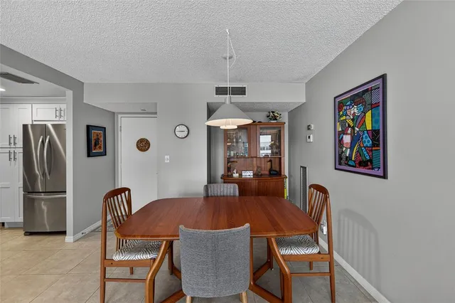 a kitchen with stainless steel appliances kitchen island granite countertop a table and chairs in it