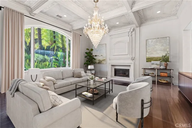 a living room with furniture a chandelier and a fireplace