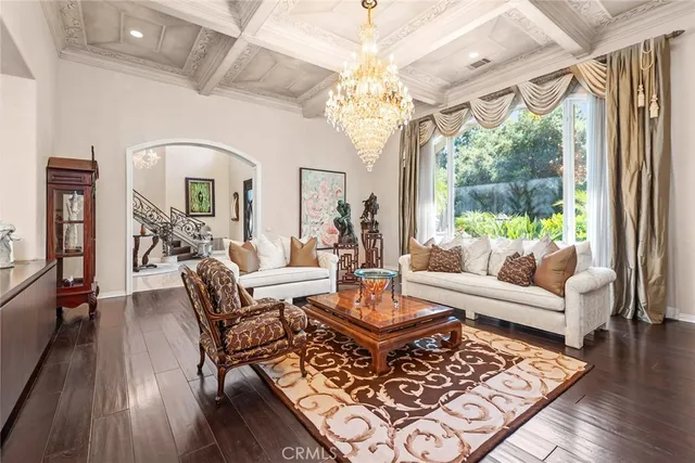 a living room with furniture large window and wooden floor