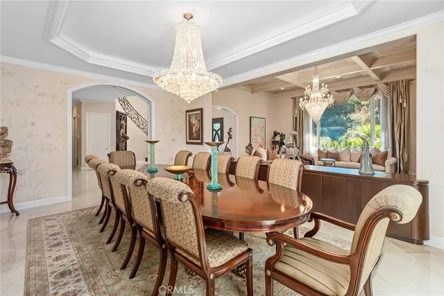 a view of a dining room with furniture a chandelier and large windows