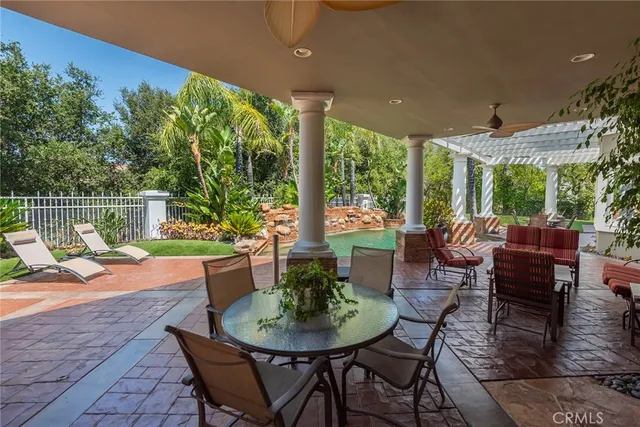 a view of a patio with a dining table and chairs with wooden floor and fence