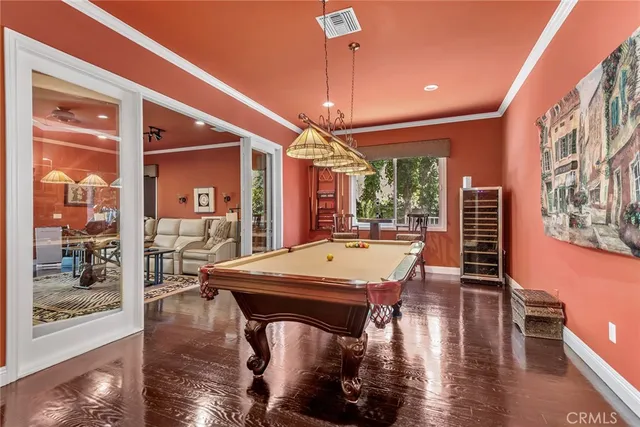 a dining hall with stainless steel appliances kitchen island granite countertop a stove a refrigerator a dining table and chairs with wooden floor