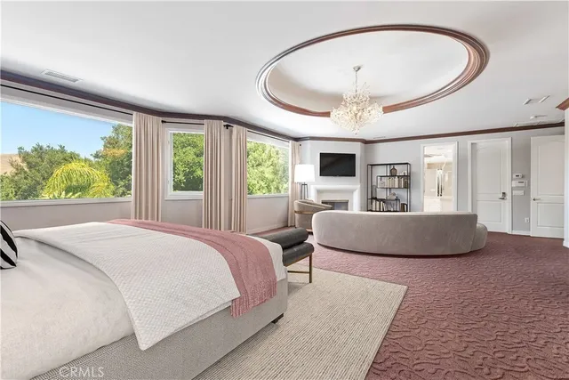 a bedroom with a large bed and a chandelier