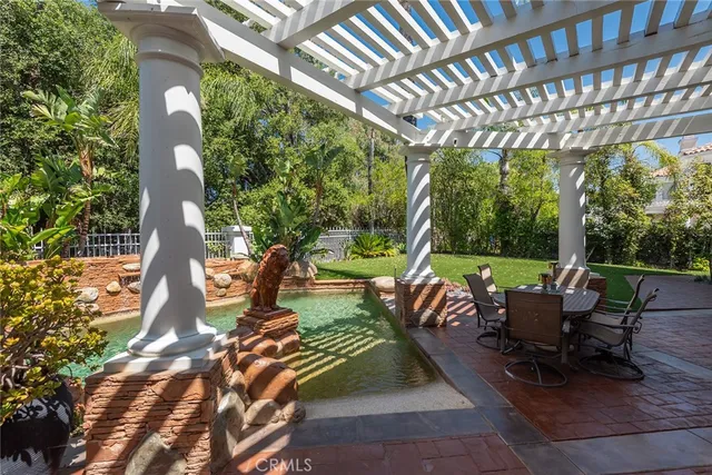 a view of yard with seating space and trees in the background