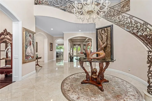a view of a hallway with wooden floor and a chandelier