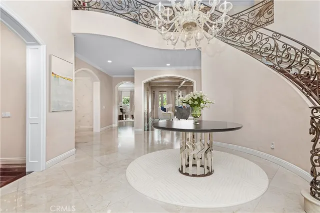 a dining room with wooden floor a chandelier a wooden table and chairs