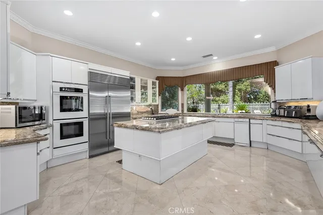 a kitchen with stainless steel appliances kitchen island granite countertop a stove and cabinets