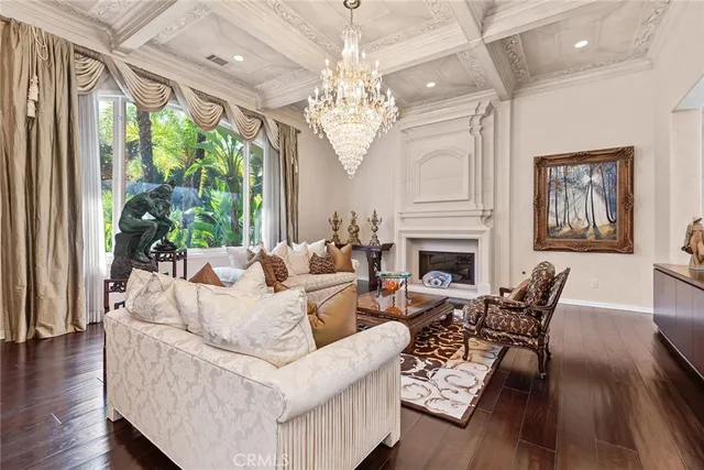 a living room with furniture a chandelier and a fireplace