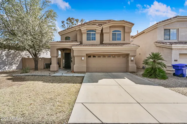 a front view of a house with a yard and a garage