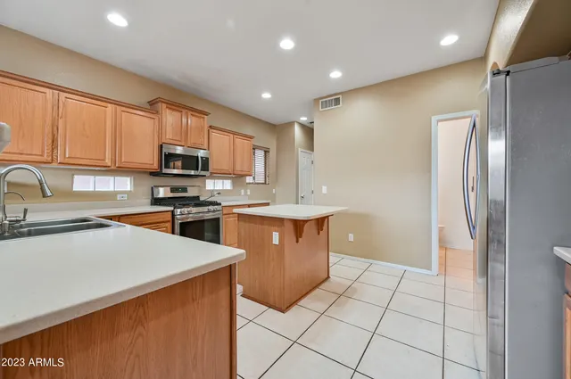 a kitchen with stainless steel appliances granite countertop a refrigerator sink and cabinets