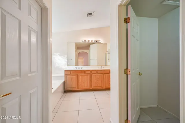 a spacious bathroom with a double vanity sink a mirror and a bathtub