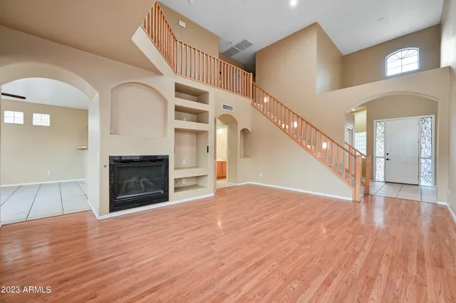 a view of empty room with wooden floor and fireplace