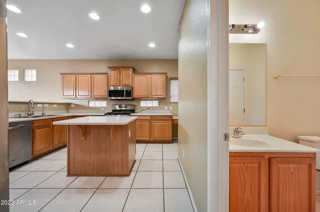 a kitchen with stainless steel appliances granite countertop a stove a sink and a refrigerator