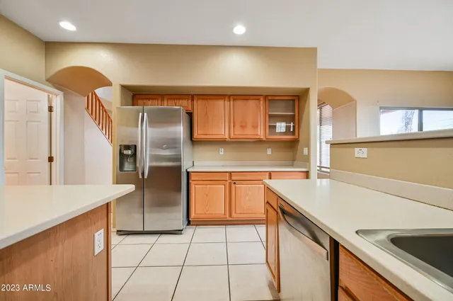 a kitchen with stainless steel appliances granite countertop a sink and a refrigerator