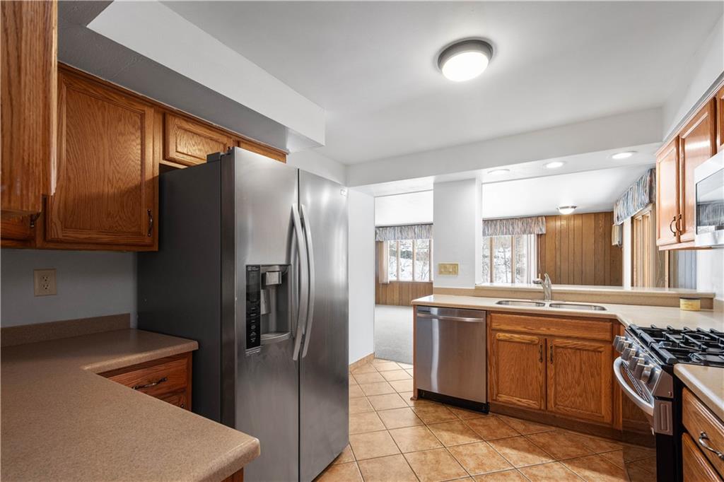 3930 Edge Road Pittsburgh, PA 15227 - Photo 12 of 45 a kitchen with stainless steel appliances granite countertop a refrigerator a sink a stove and white cabinets with wooden floor