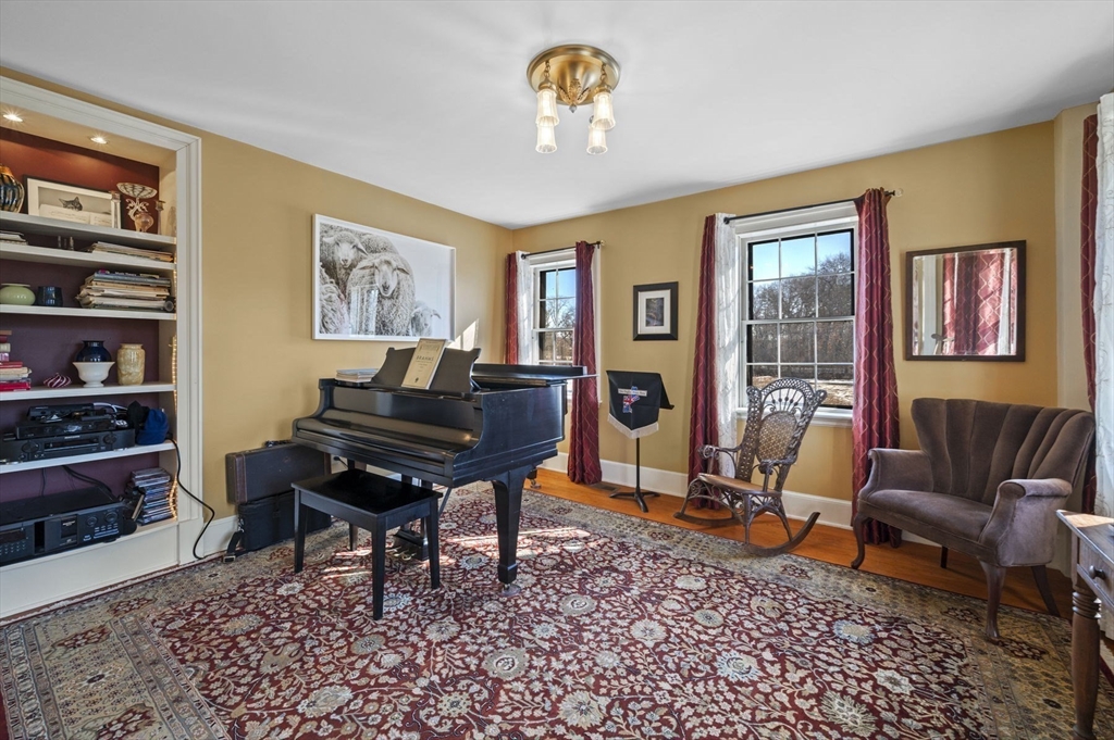 9 River Road Topsfield, MA 01983 - Photo 19 of 42 a living room with furniture a piano and a bookshelf