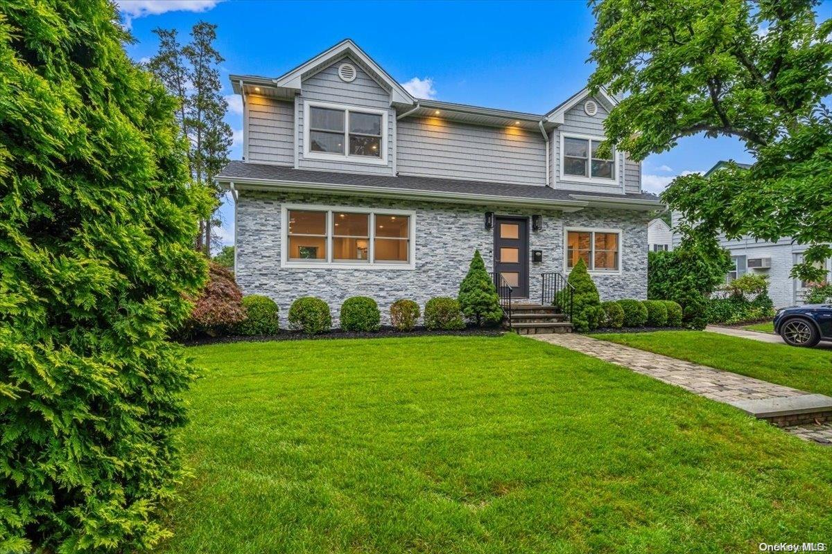 139 Vanderbilt Avenue Manhasset, NY 11030 - Photo 1 of 1 a front view of a house with a yard and garage