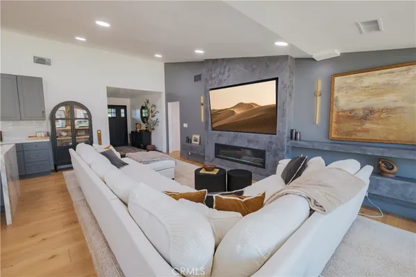 a living room with furniture and a view of kitchen