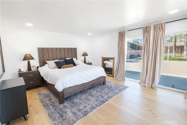 a bedroom with a bed and a lamp on dresser