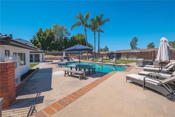 a view of a house with a yard and a large tree