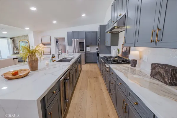 a large kitchen with stainless steel appliances and a large counter top