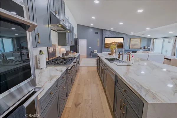 a kitchen with stainless steel appliances a table chairs refrigerator and wooden cabinets