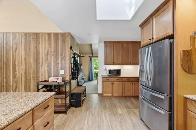 a kitchen with a refrigerator a stove and wooden cabinets