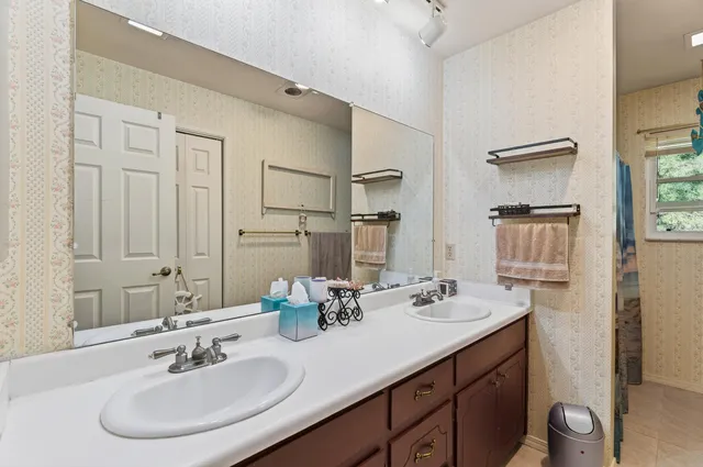 a bathroom with double sink and a mirror