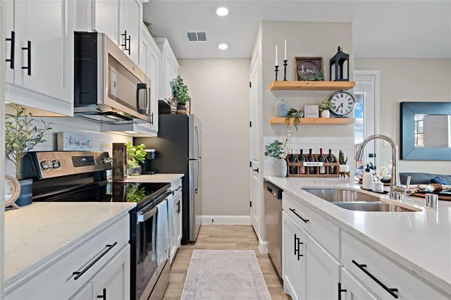 a kitchen with stainless steel appliances granite countertop a sink a stove and a refrigerator