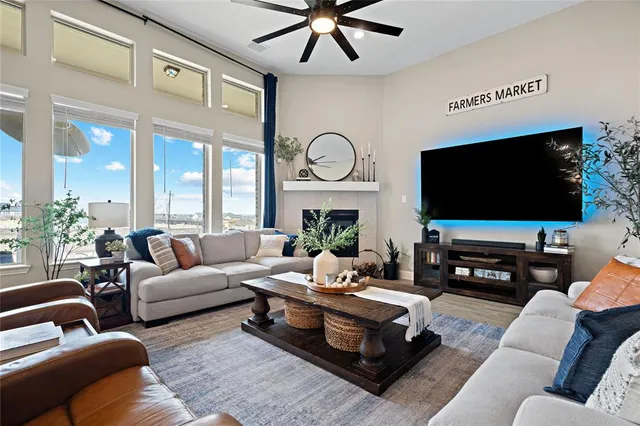a living room with furniture a large window and a flat screen tv