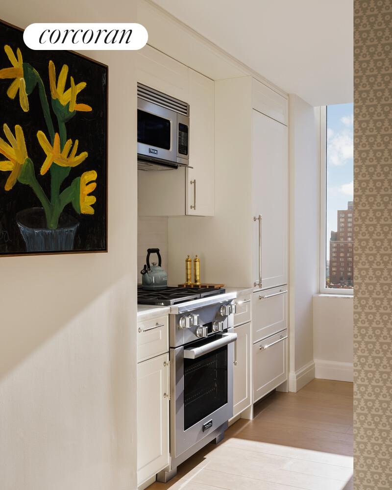 400 East 84th Street, Unit 22C Manhattan, NY 10028 - Photo 5 of 10 a kitchen with stainless steel appliances a stove and a microwave