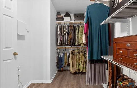 a view of walk in closet with clothes