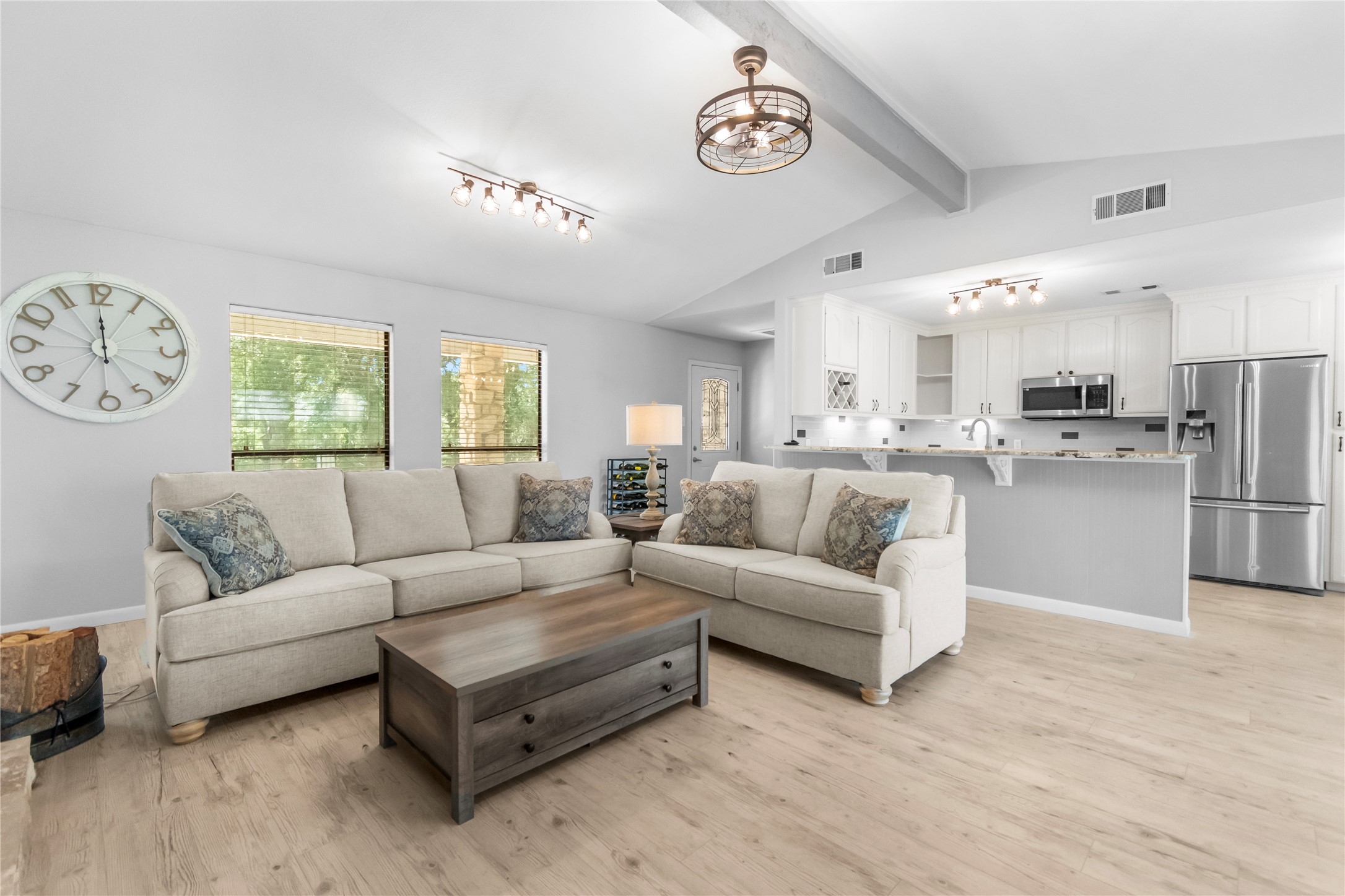 210 Teeoff, Unit B Horseshoe Bay, TX 78657 - Photo 9 of 38 An open concept living area boasts a vaulted ceiling and light-toned flooring throughout.