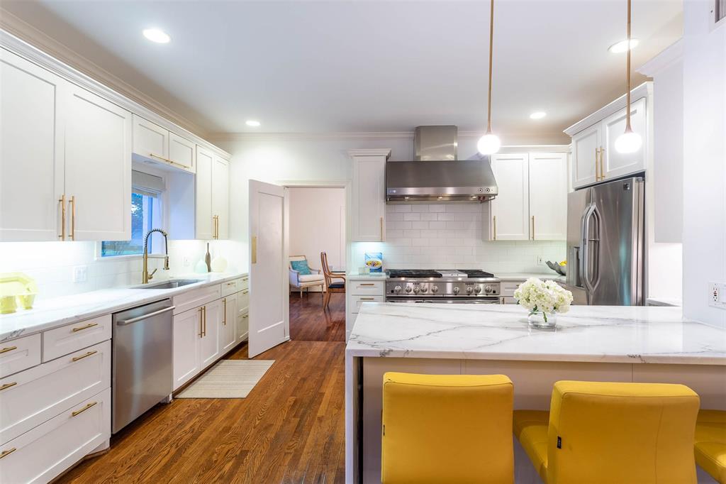 a kitchen with stainless steel appliances granite countertop a sink a stove and refrigerator
