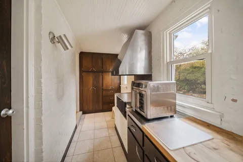 a kitchen with granite countertop a stove a sink and a refrigerator