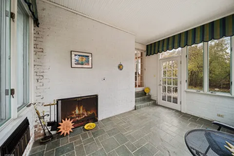a view of an empty room with furniture a fireplace and a window